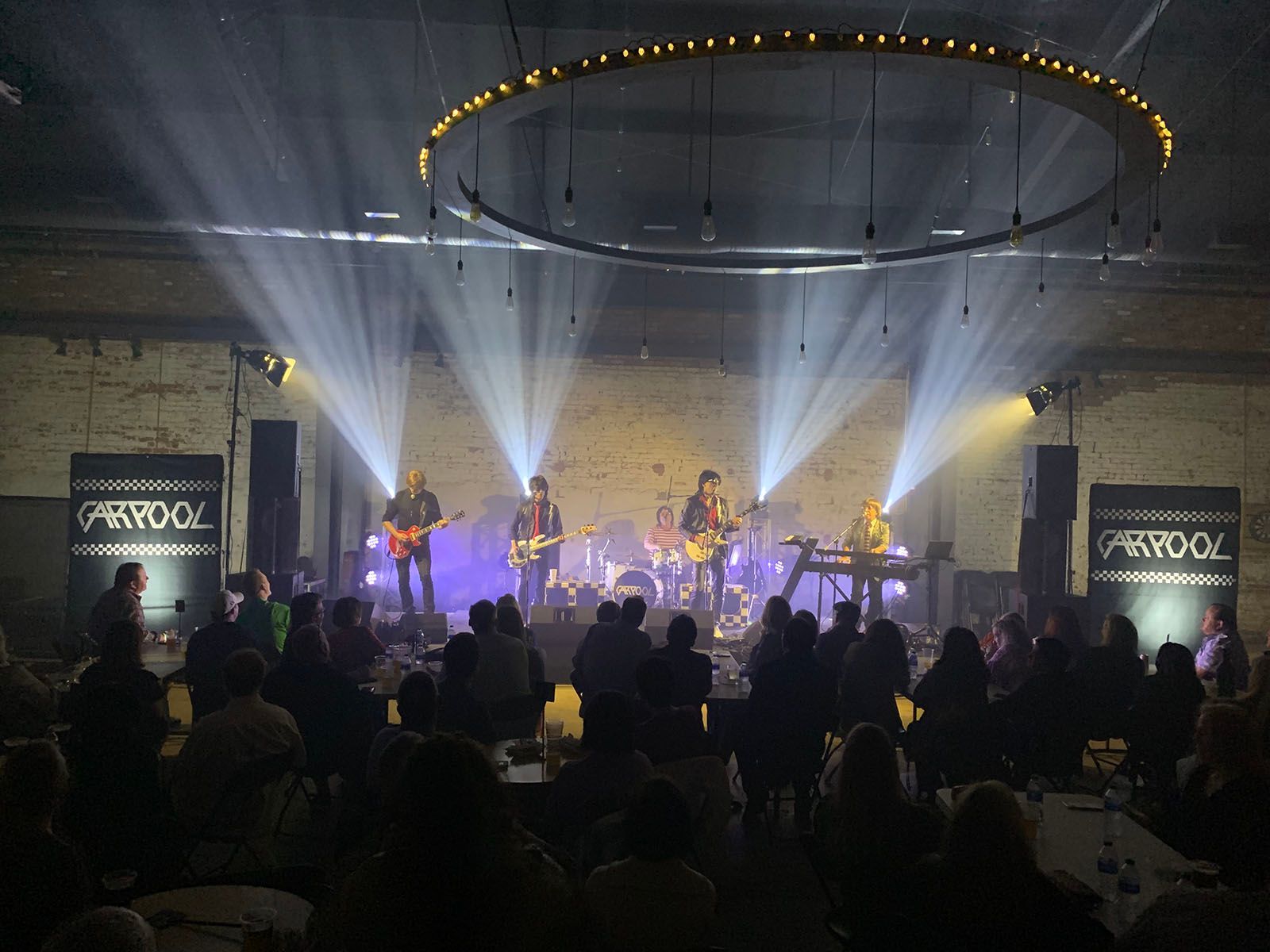 A group of people watching a band on stage