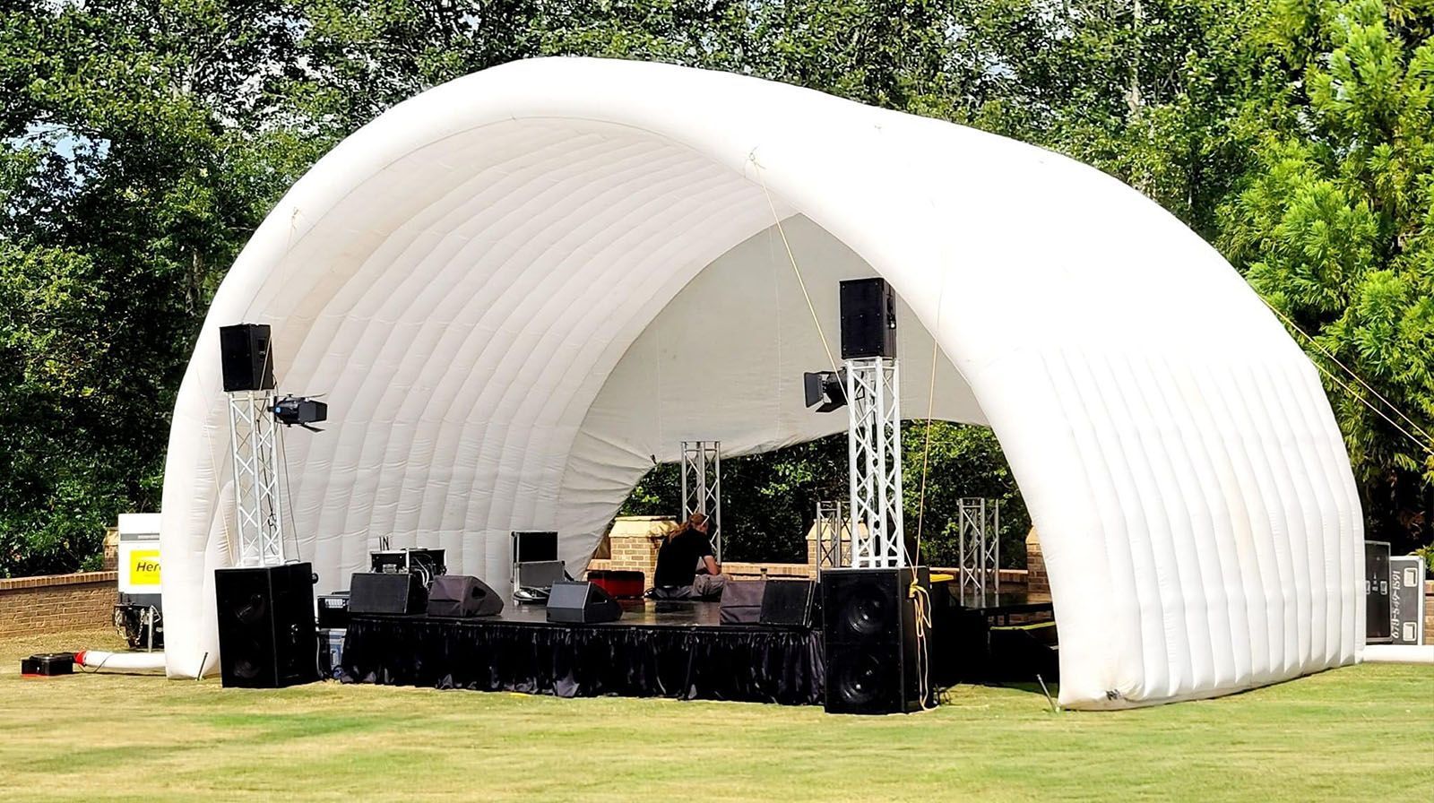 A large white tent is sitting in the middle of a grassy field