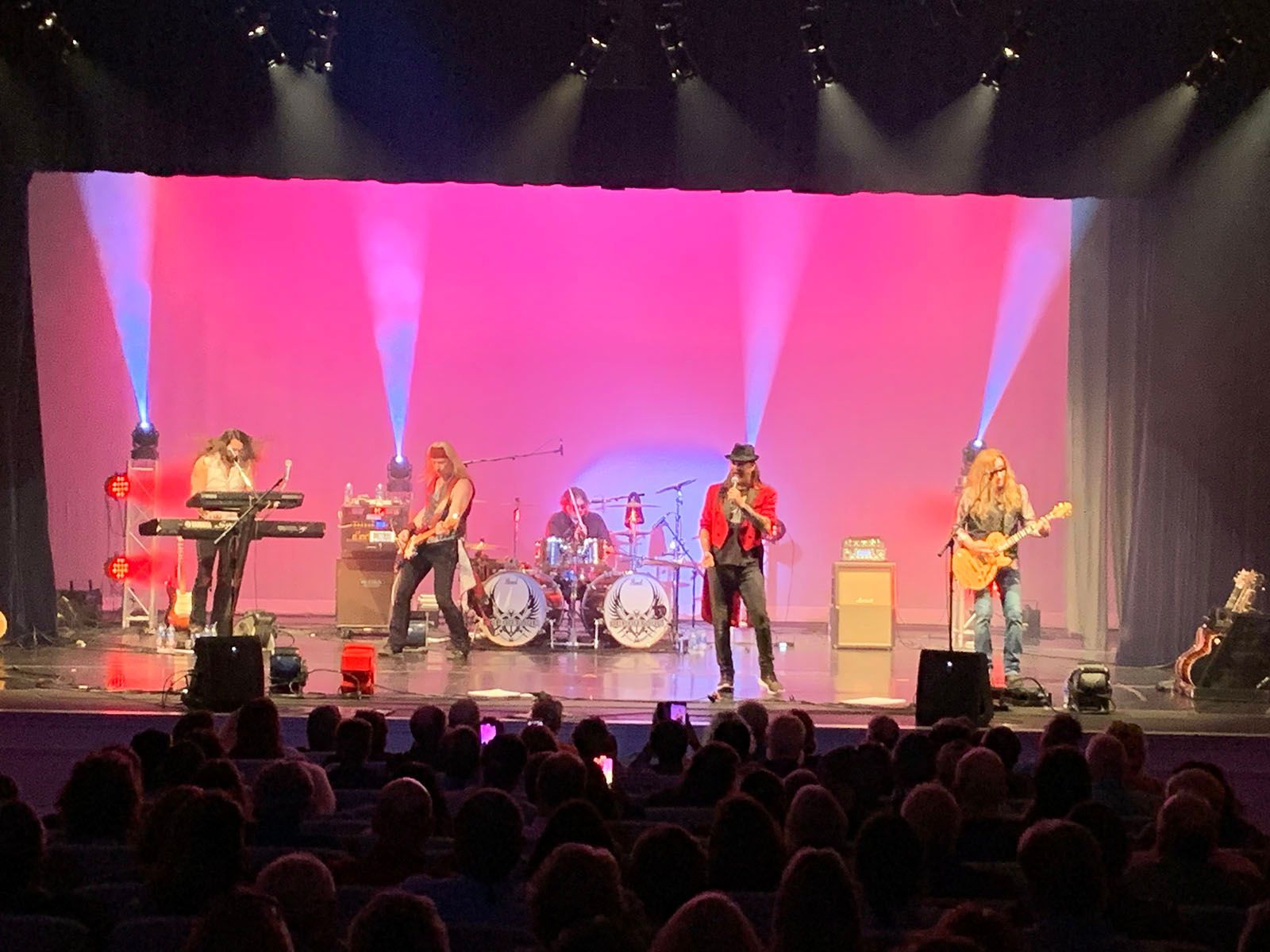 A group of people are playing instruments on a stage in front of a crowd