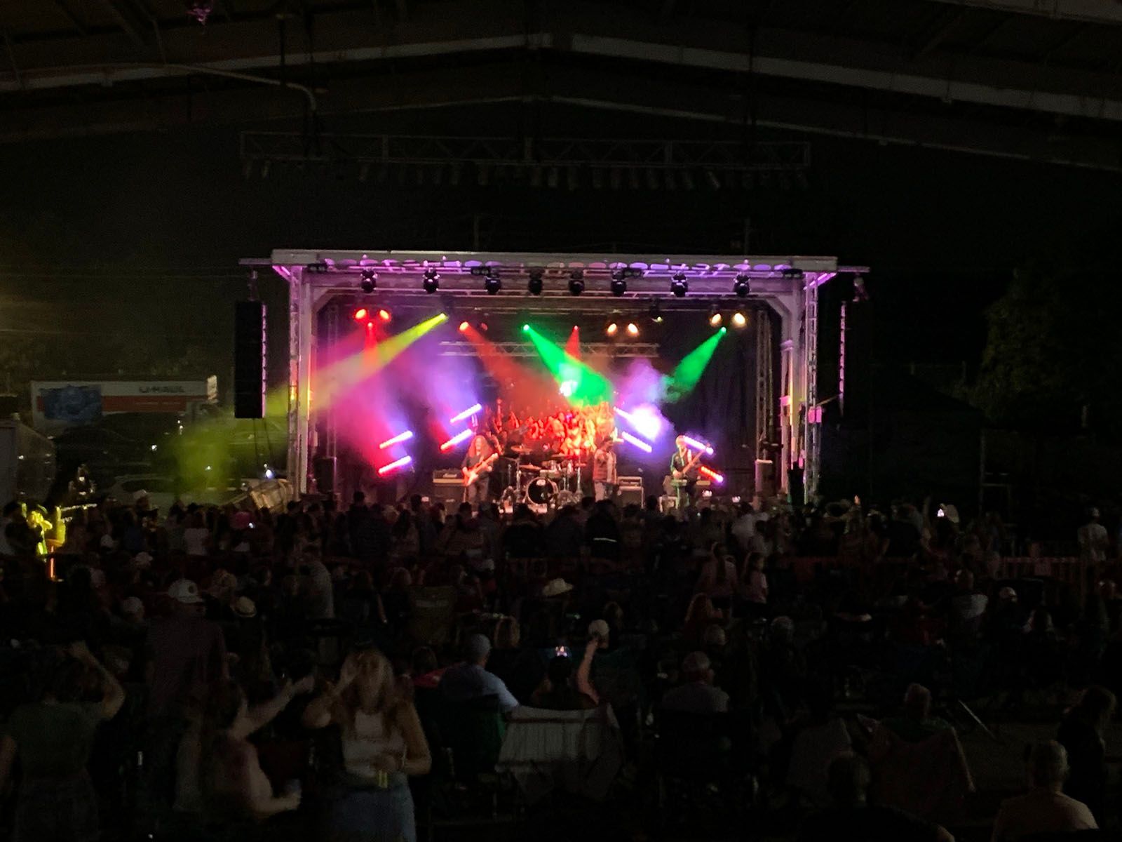 A group of people are standing in front of a stage at a concert