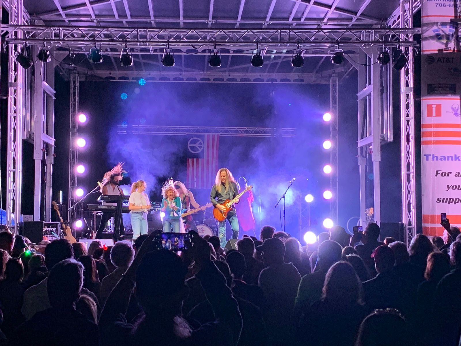 A group of people are playing instruments on a stage in front of a crowd