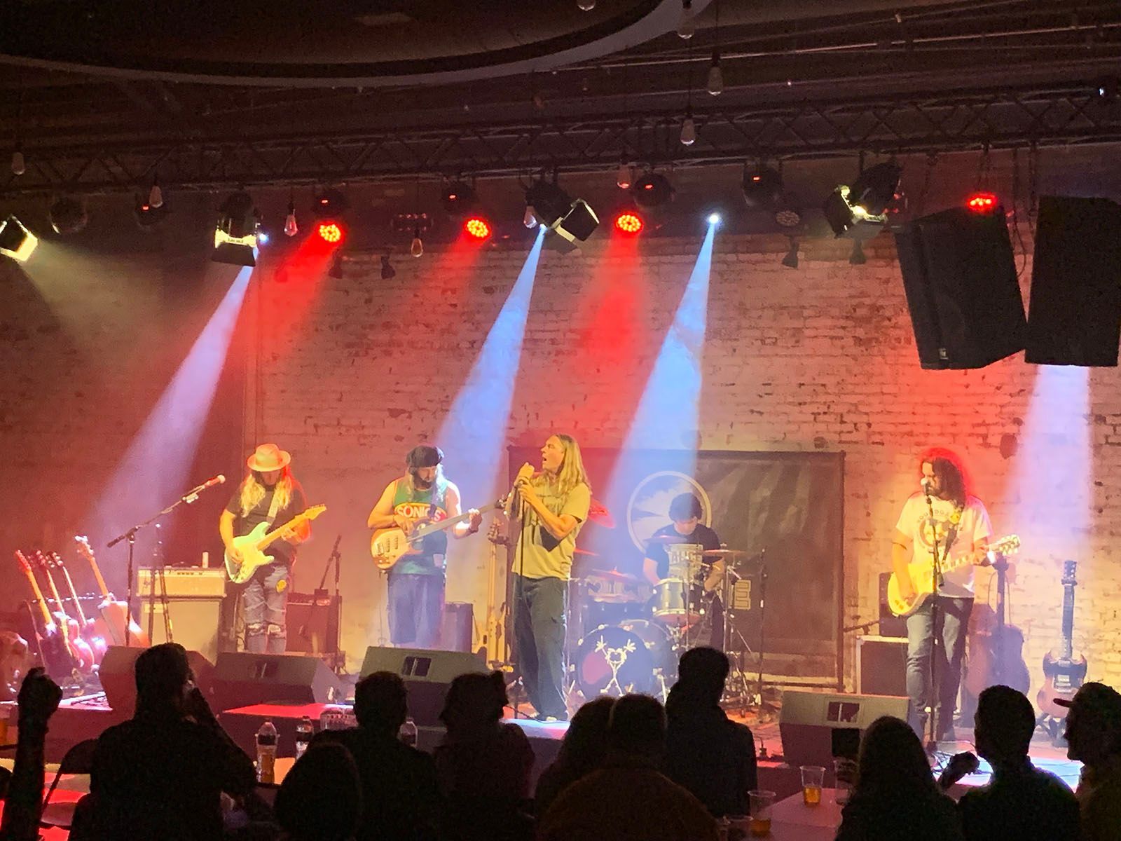 A group of people playing instruments on a stage in front of a crowd