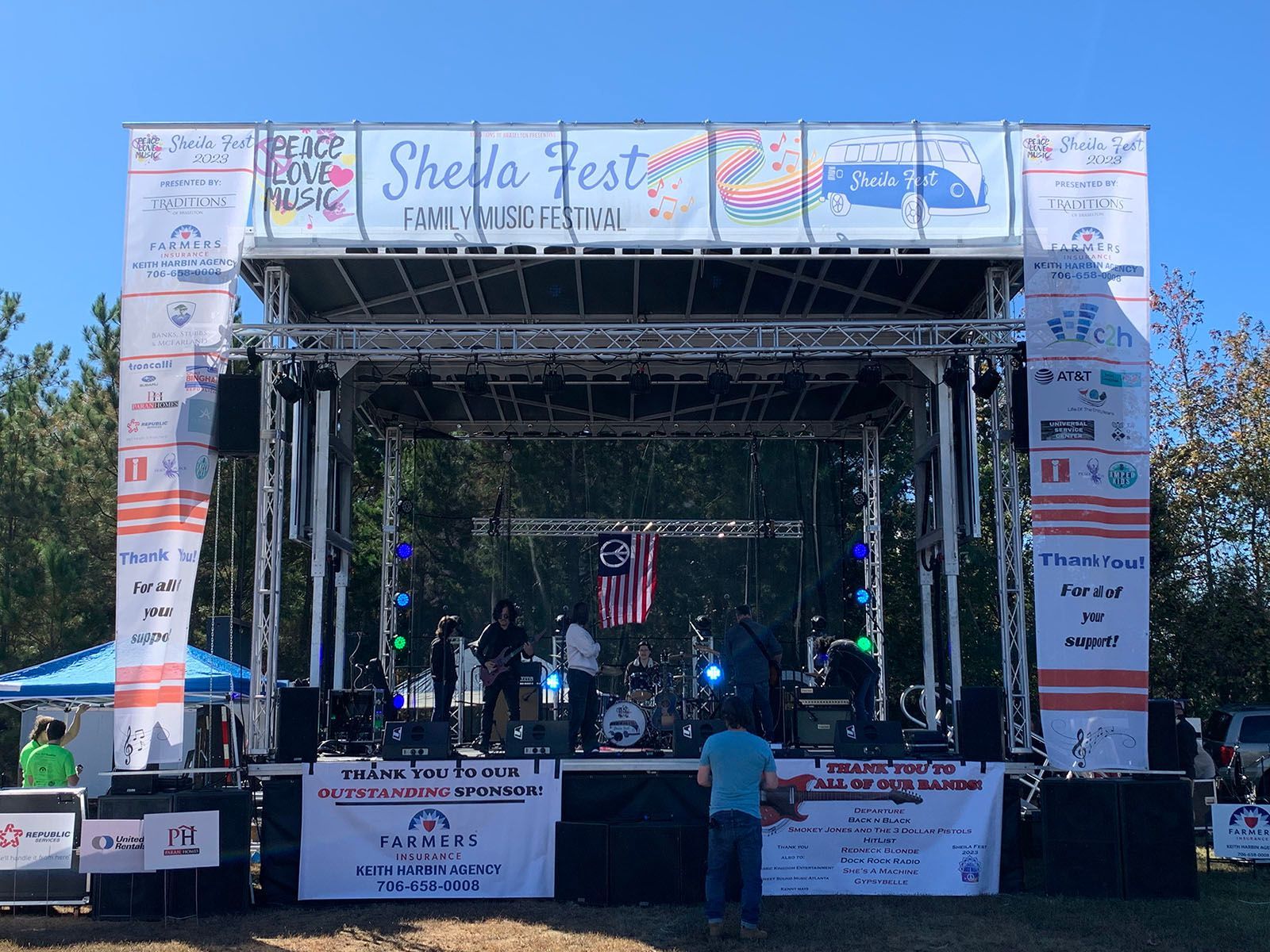 A large stage at a festival with a band on it