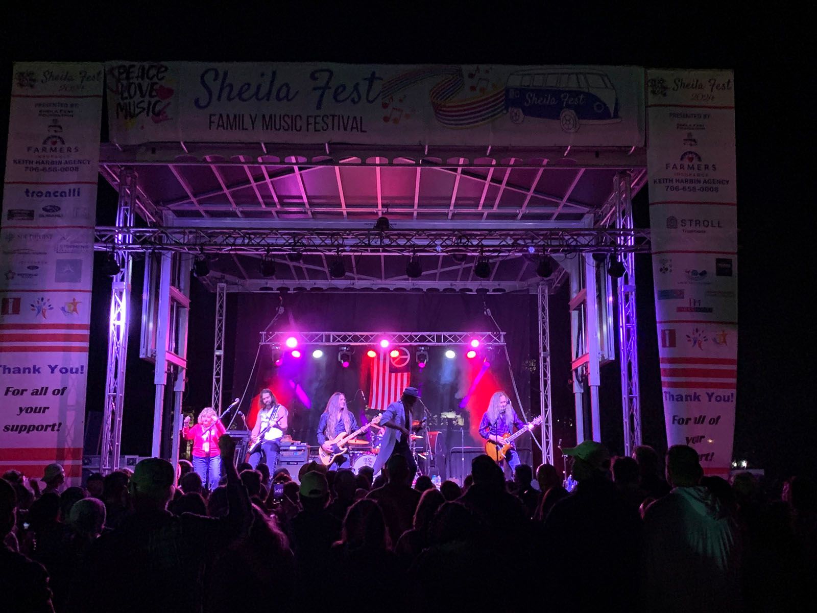 A group of people are playing instruments on a stage at a concert