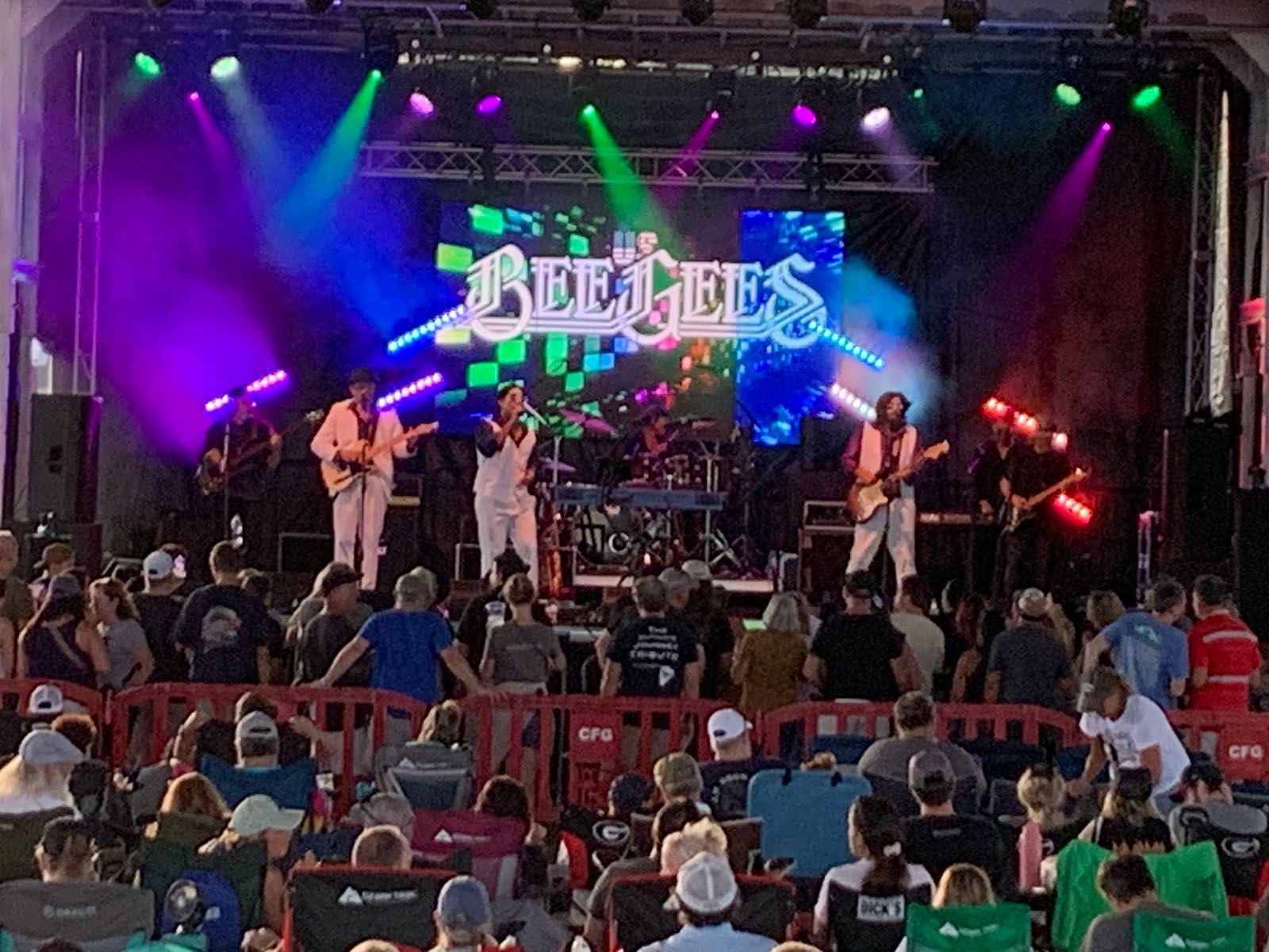 A group of people are sitting in front of a stage that says adelaide on it