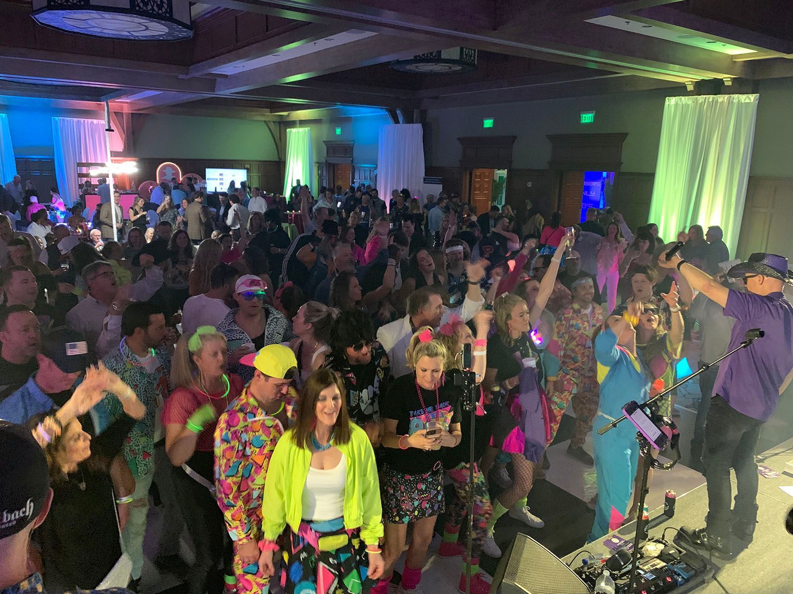 A large group of people are standing in a room at a party