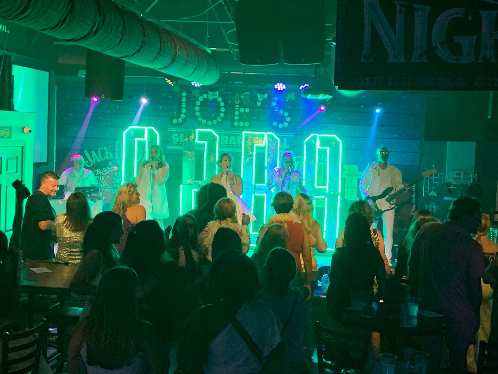 A crowd sitting in front of a stage at a concert