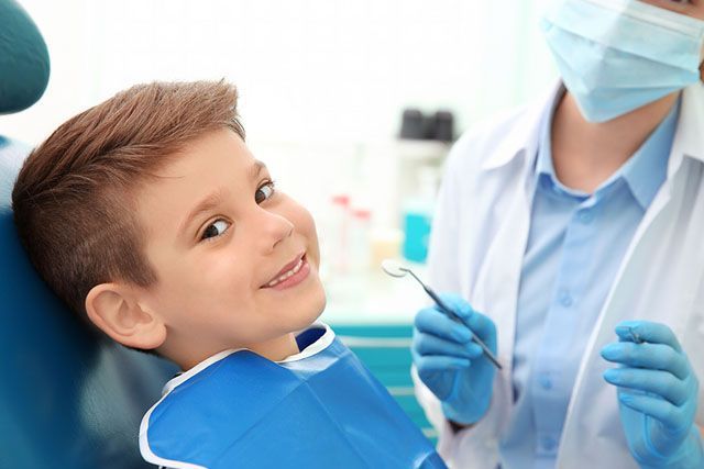 Young boy smiling in dentist chair