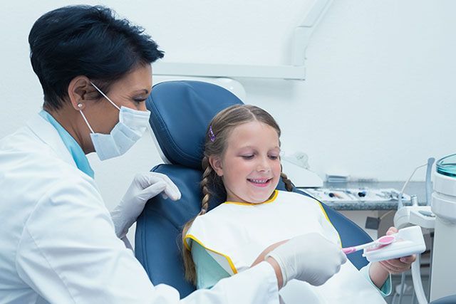 Smiling young girl in dentist chair