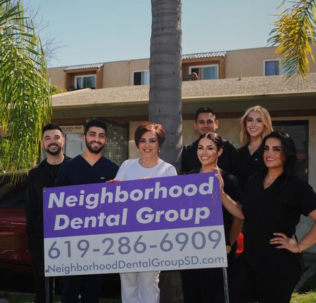 Group of dental staff holding a sign for Neighborhood Dental Group
