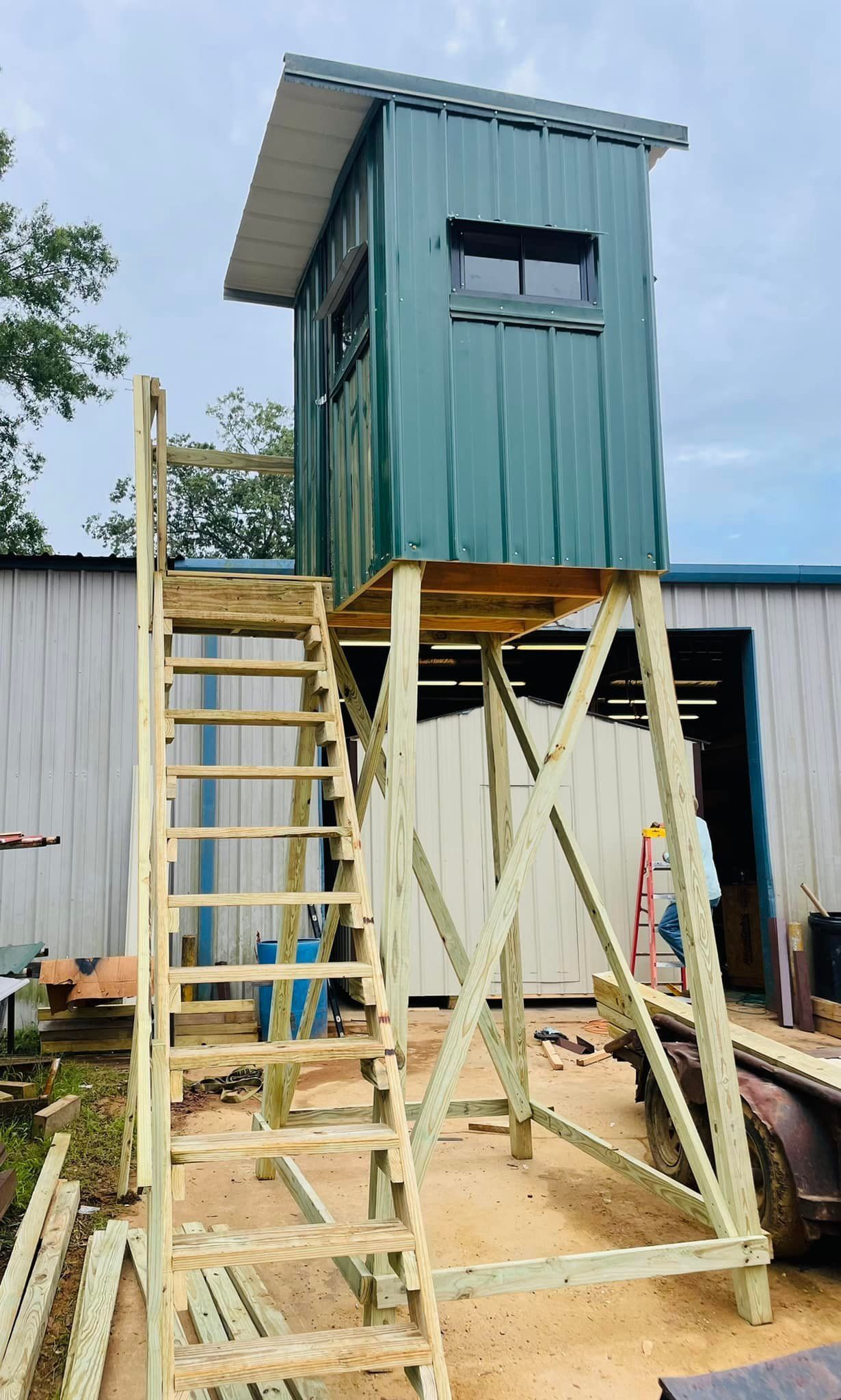 A wooden tower with stairs is being built in front of a building.