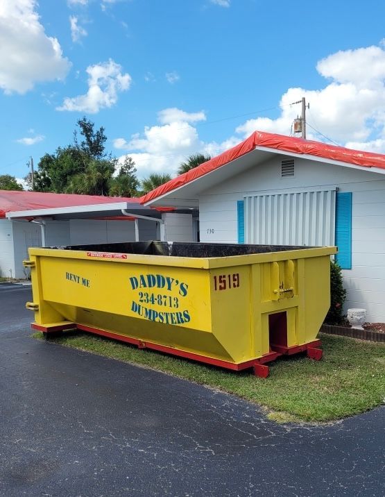 Yellow 15-yard dumpster from Daddy’s Dumpsters placed in a residential neighborhood.