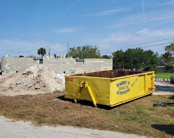 A yellow dumpster with the word daddy 's on it