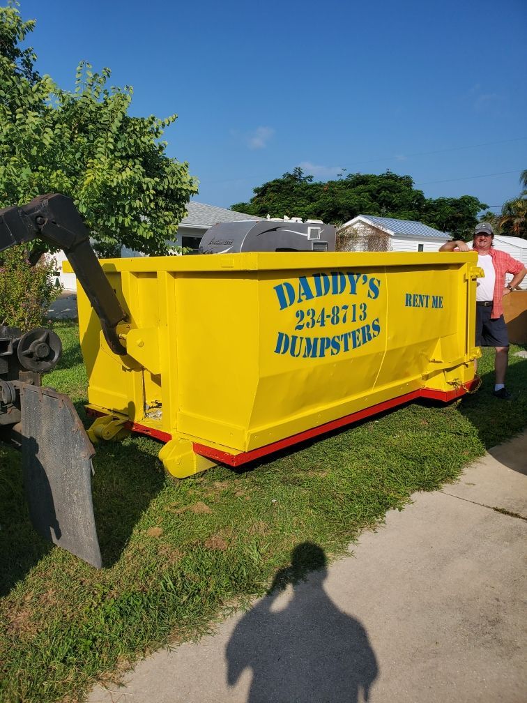 A yellow dumpster is parked on the side of the road. Roll-Off Dumpster Rental in Sarasota.