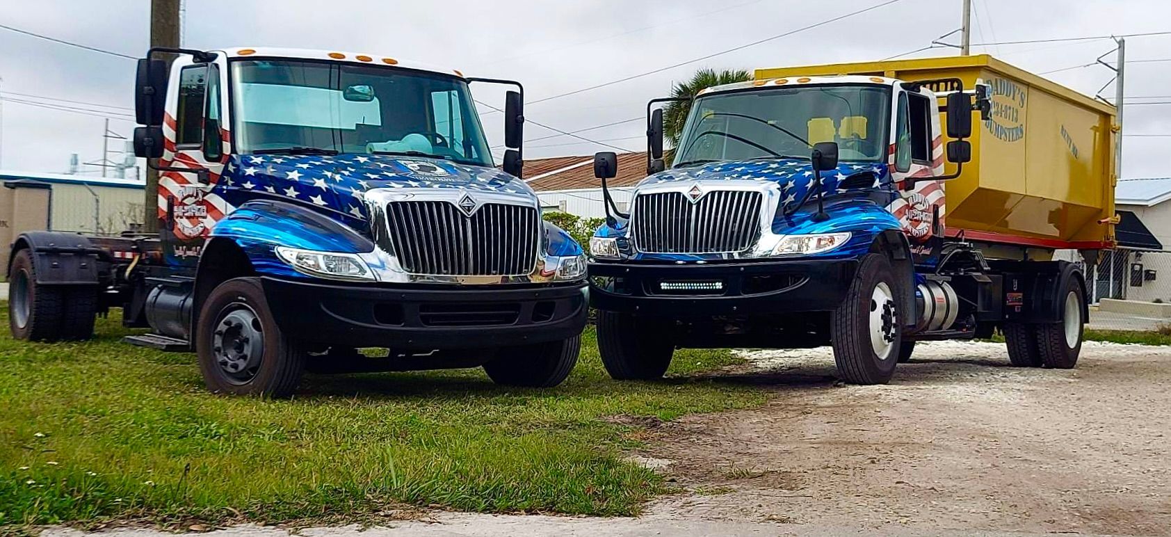 Two dump trucks are parked next to each other on a dirt road. Roll-Off Dumpster Rental in Sarasota.