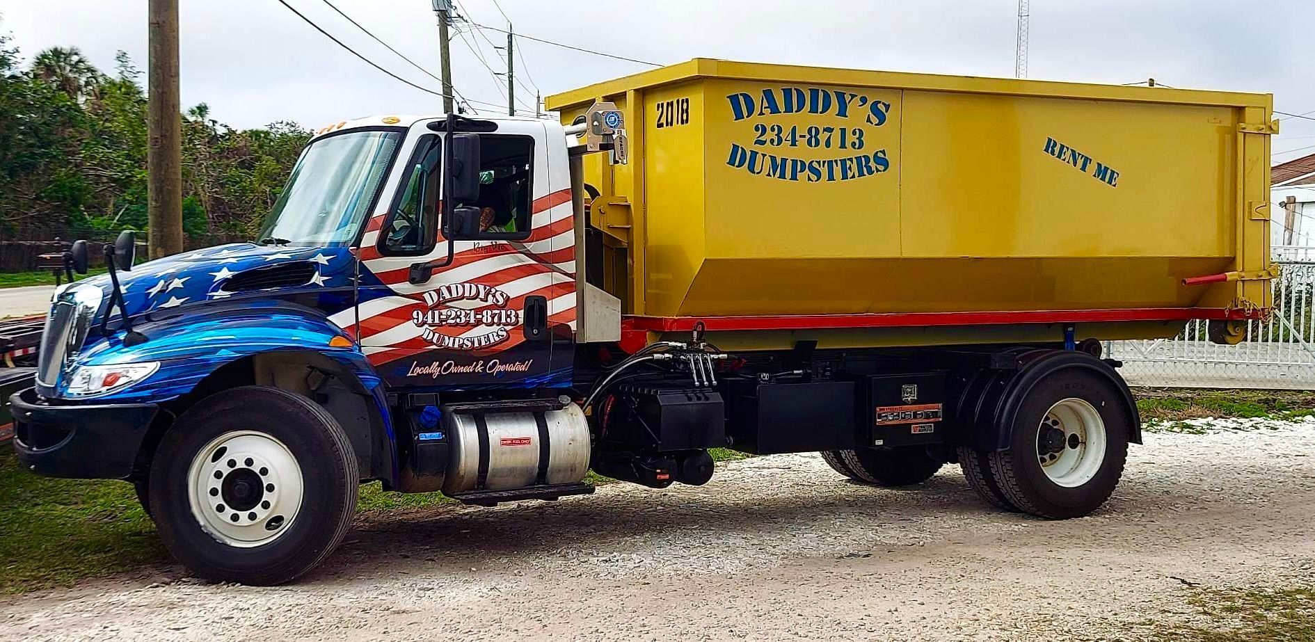 A dumpster truck is parked on the side of the road. Roll-Off Dumpster Rental in Sarasota.