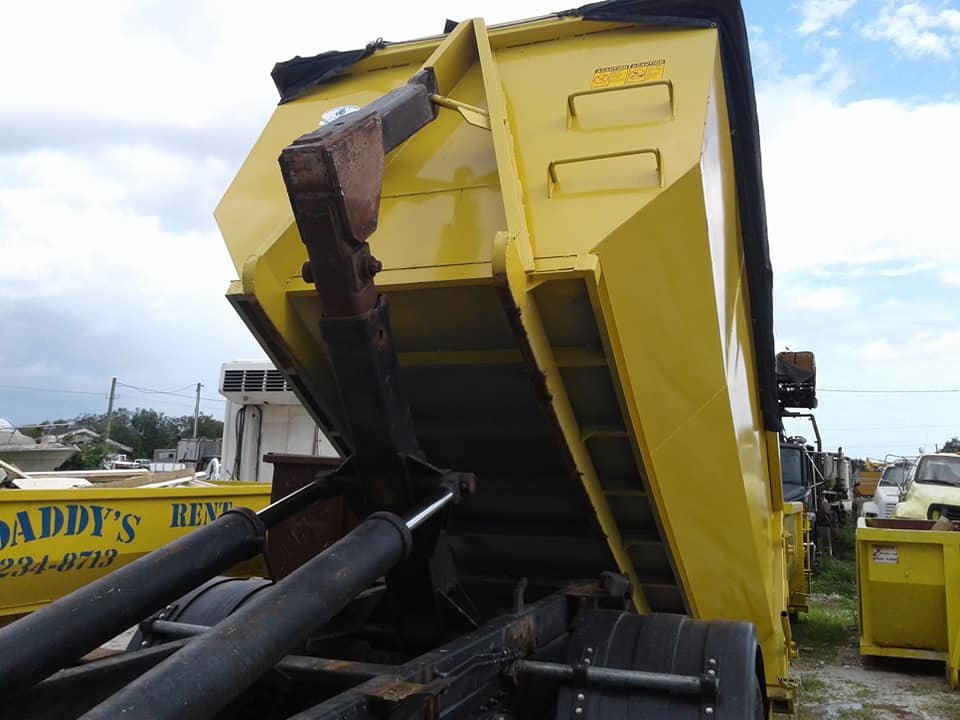 A yellow dumpster with the word Daddy's on it. Roll-Off Dumpster Rental in Sarasota.