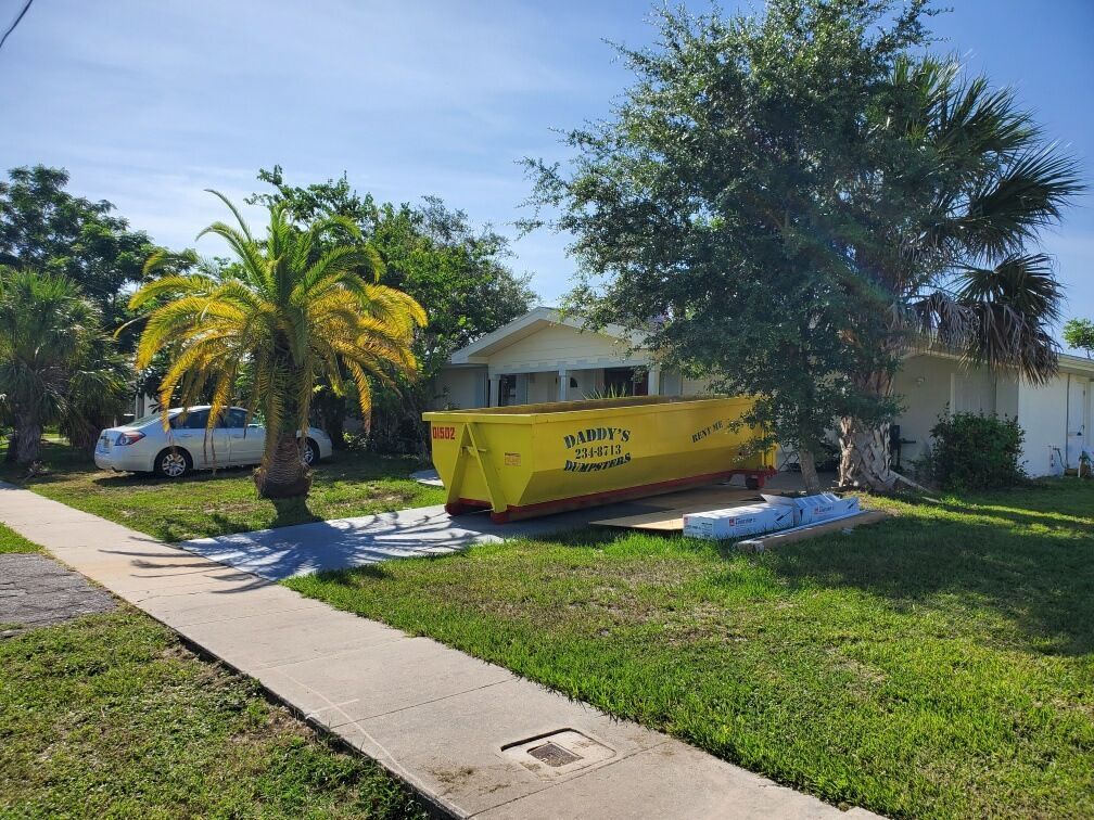 A neat-looking dumpster is parked in front of a house. Roll-Off Dumpster Rental in Sarasota.