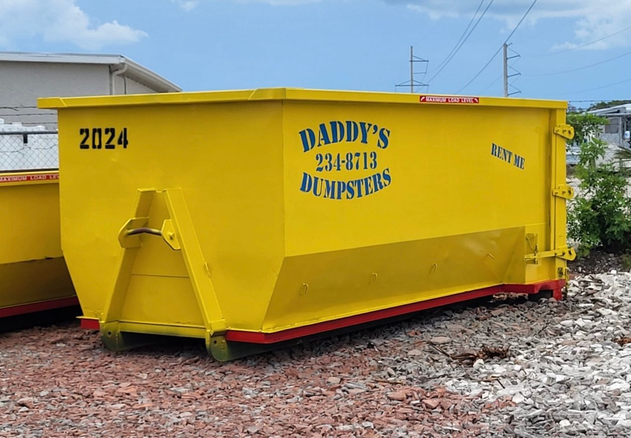 20-yard yellow dumpster marked “Daddy’s Disposal & Services” in a gravel lot
