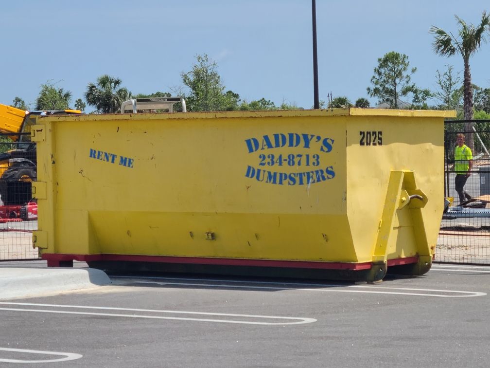 20-yard yellow Dumpster's dumpster trailer on a street with blue company lettering and red base