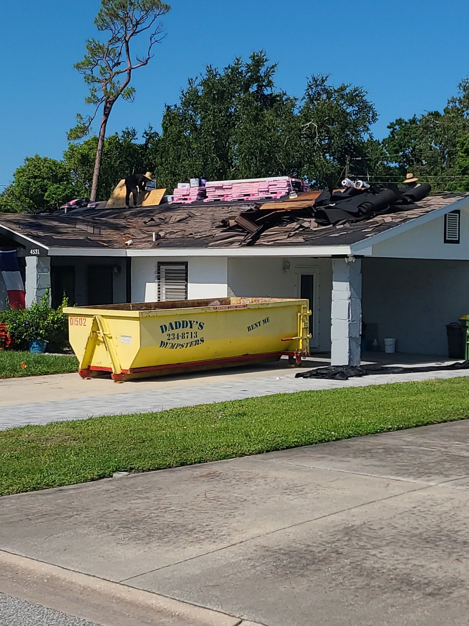 15 yard yellow dumpster in the driveway