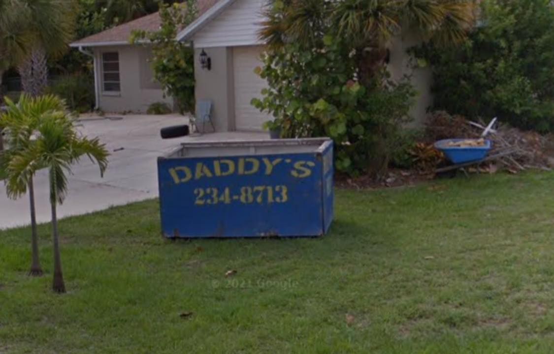 Original blue Daddy’s Dumpsters container placed in a residential front yard — proudly serving the community since 2005.