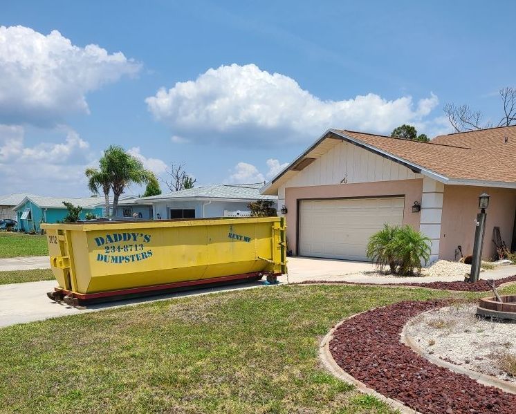 Roll-off dumpster placed in residential driveway for home renovation cleanup in Sarasota, Florida