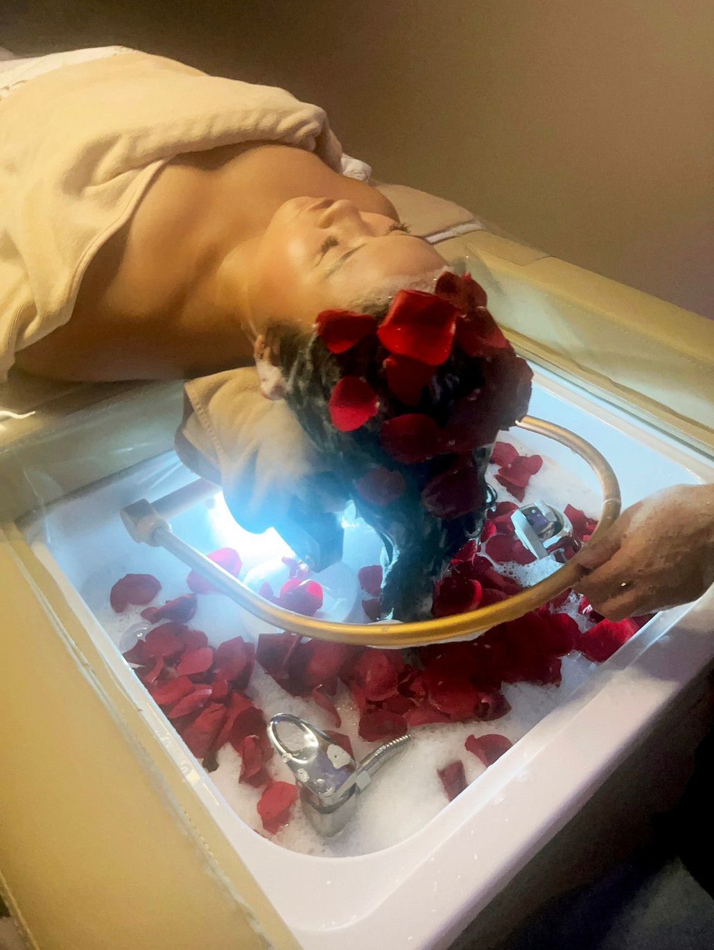 Red roses spilling from a white gift box on a golden tray with a cream ribbon.