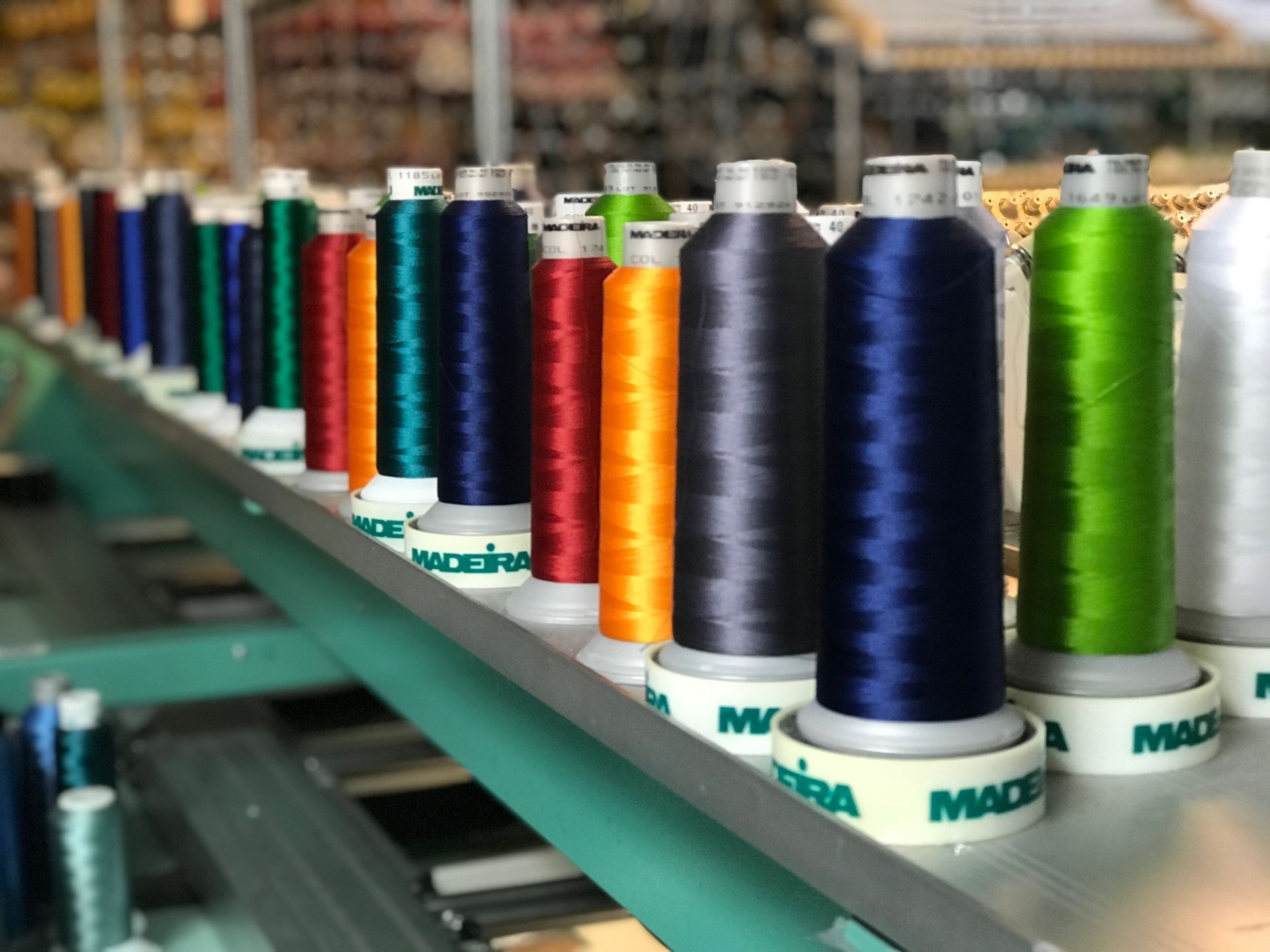 A bunch of spools of thread are lined up on a table