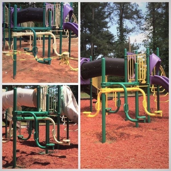 Playground equipment with green and yellow metal poles, purple slides, and a tan base.