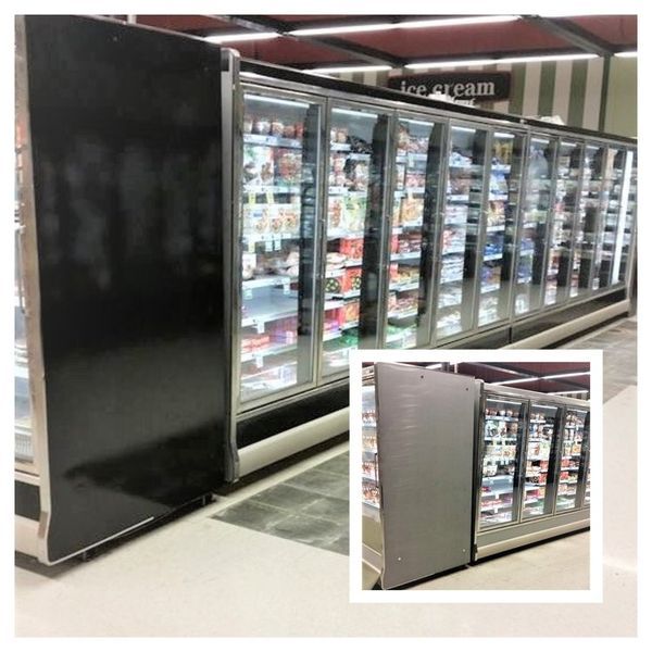 Long row of glass-doored freezers in a grocery store, full of food products. Black side panels, gray floors.