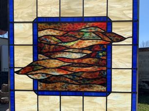 stained glass window: abstract landscape in earth tones framed in blue and cream squares