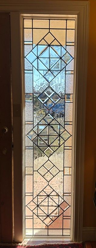 stained glass sidelight with geometric patterns in a doorway