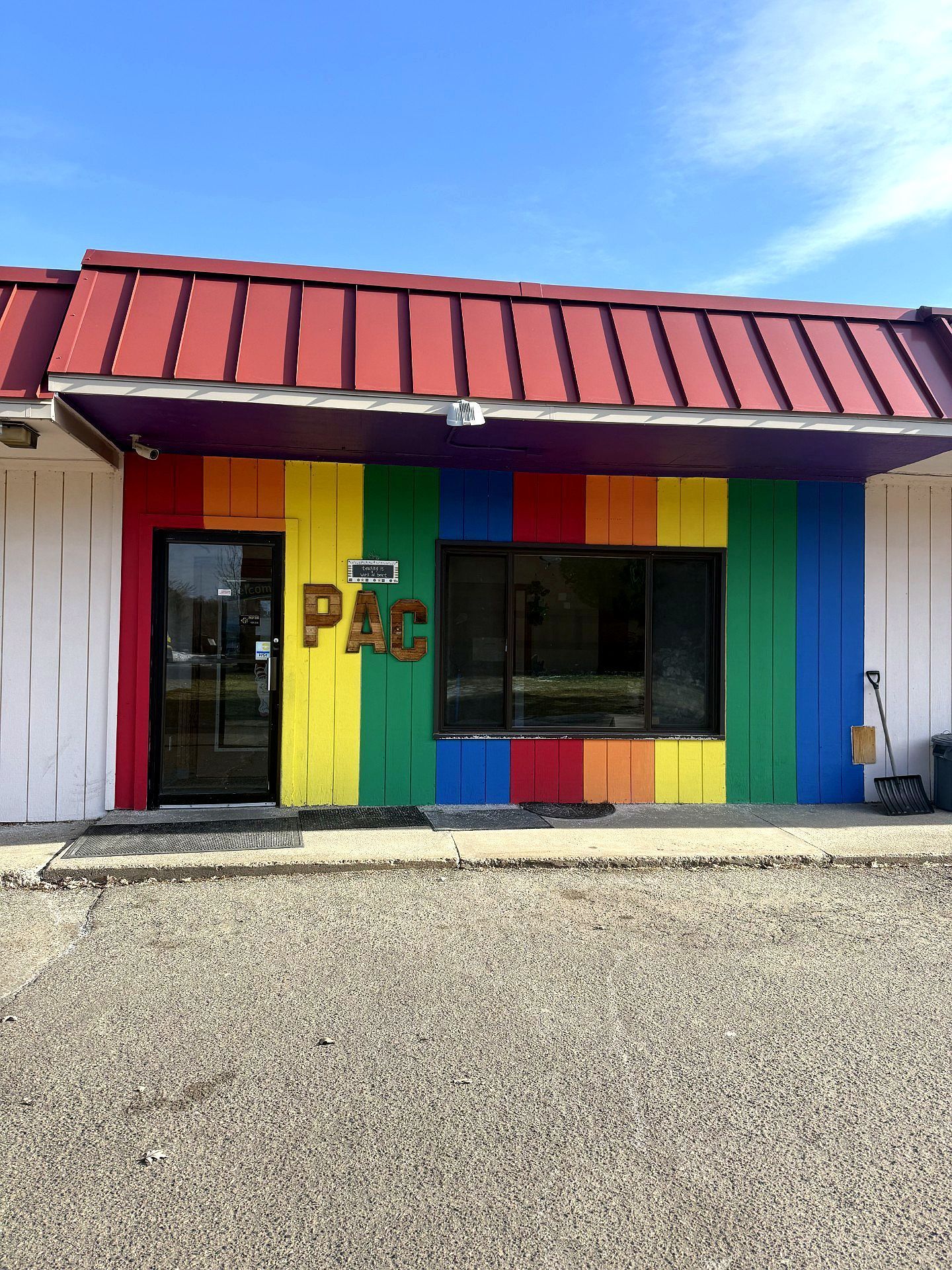Building with a rainbow-painted facade and red roof, the letters PAC are visible.