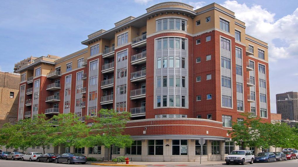 Large apartment building and trees along the street.