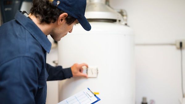 A man is looking at a water heater 