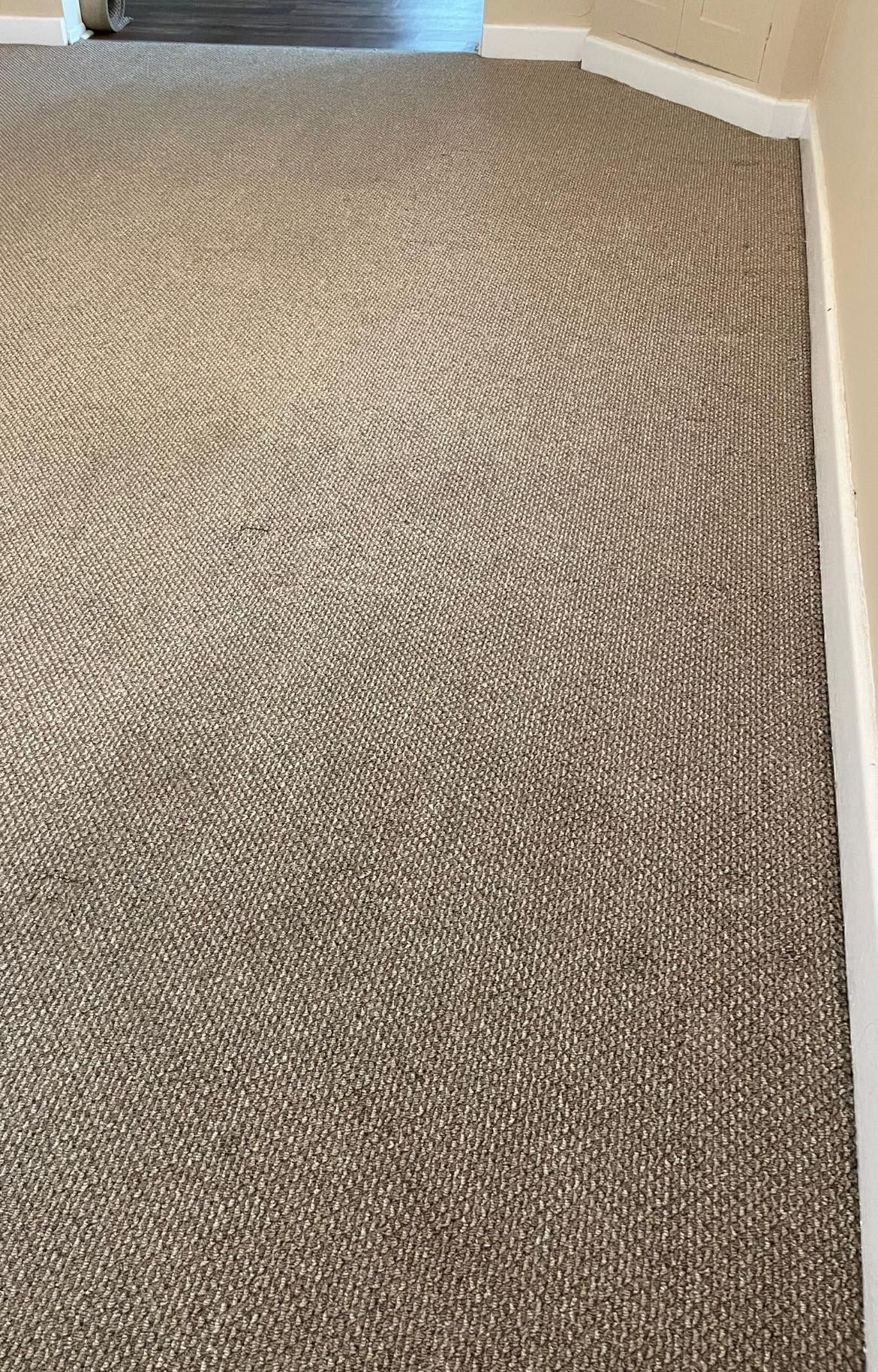 a beige carpet with white trim on walls