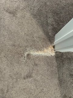 torn carpet near a white door frame