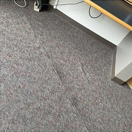 a gray carpet floor with visible seam