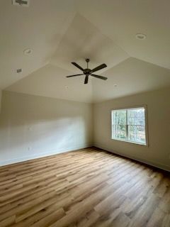 an empty room with hardwood floors and a ceiling fan