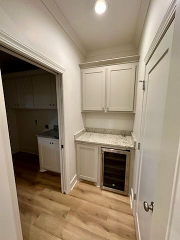 a kitchen with white cabinets and a wine cooler