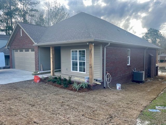 a brick house with a porch and a garage is being built
