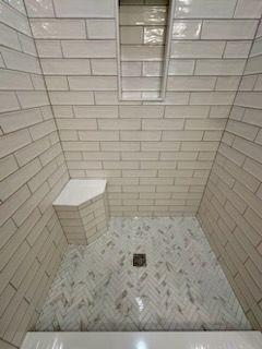a bathroom with white tiles and a walk in shower