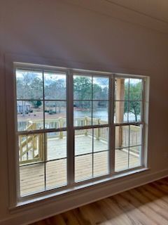 a large window in an empty room with a view of a deck