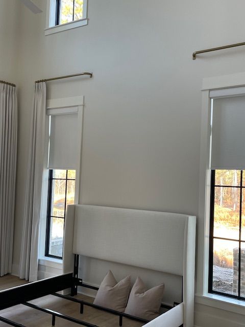 A minimalist white bedroom with white bed frame