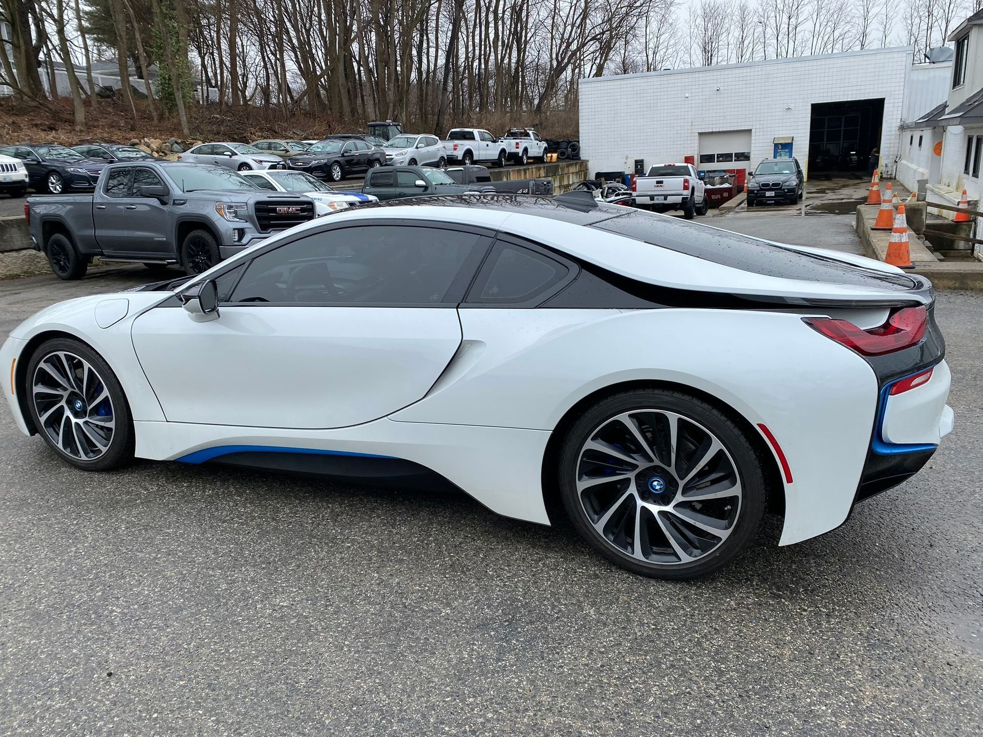 A white bmw i8 is parked in a parking lot.