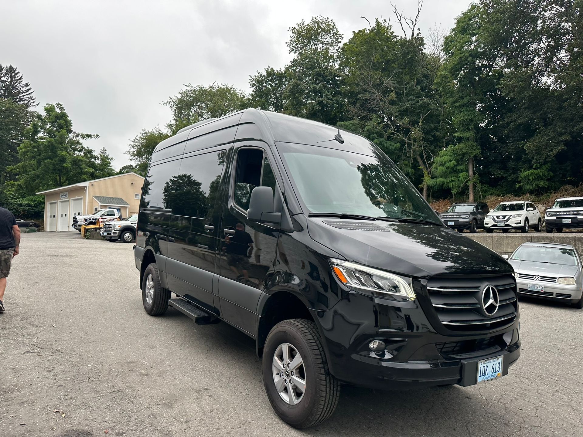A black mercedes benz sprinter van is parked in a parking lot.