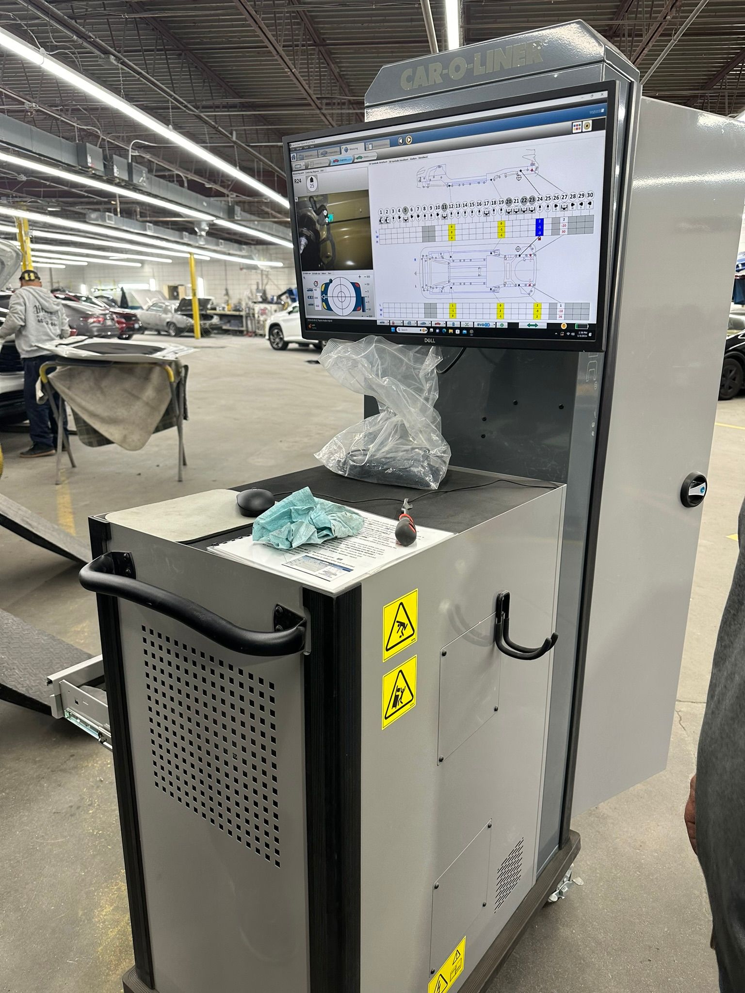A computer monitor is sitting on top of a cart in a factory.