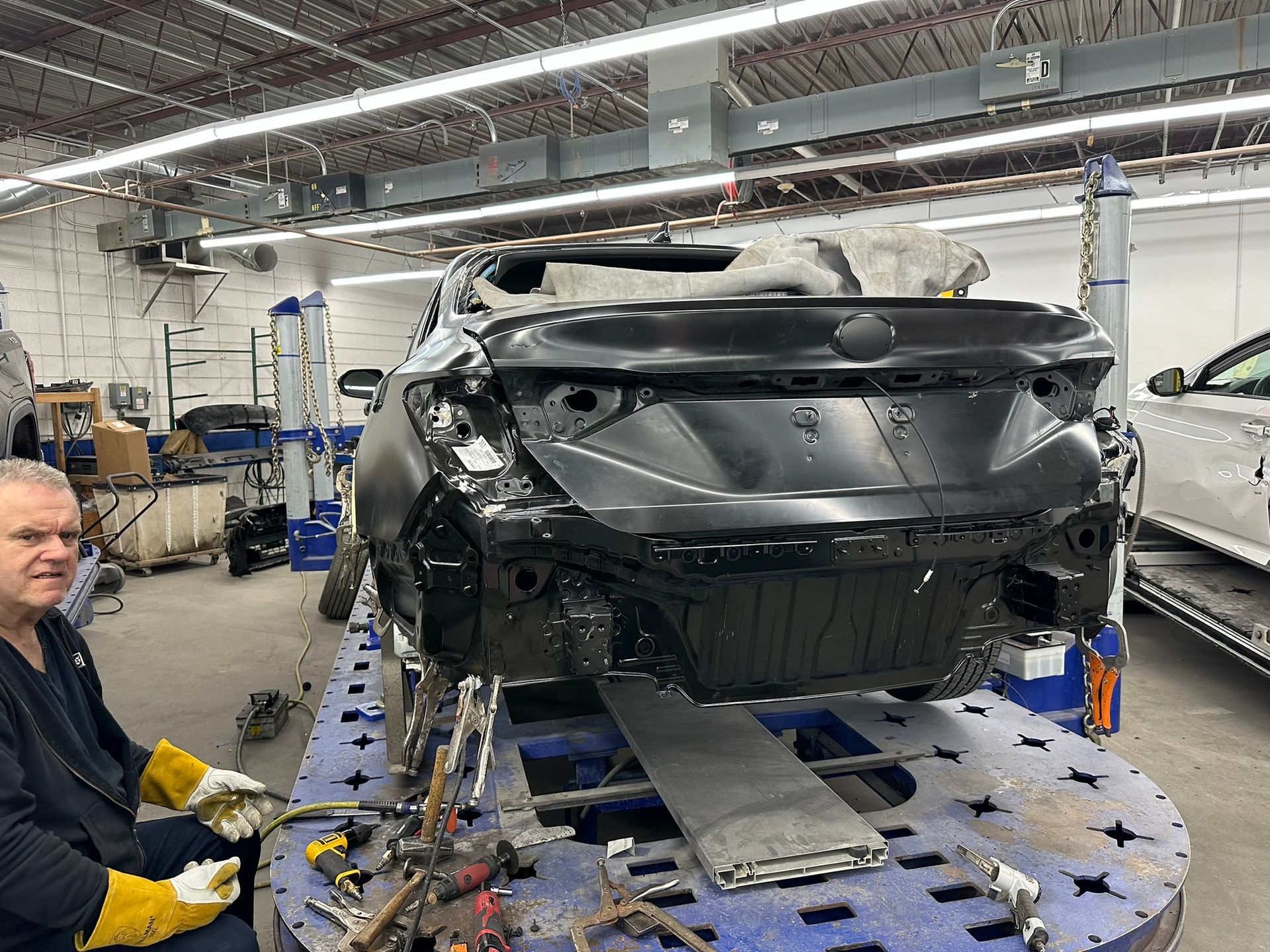 A man is working on a car in a garage.