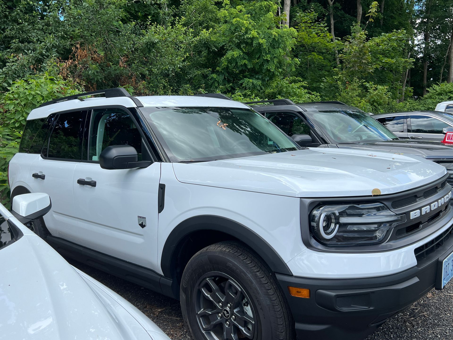 A row of white ford bronco sport suvs are parked in a lot.